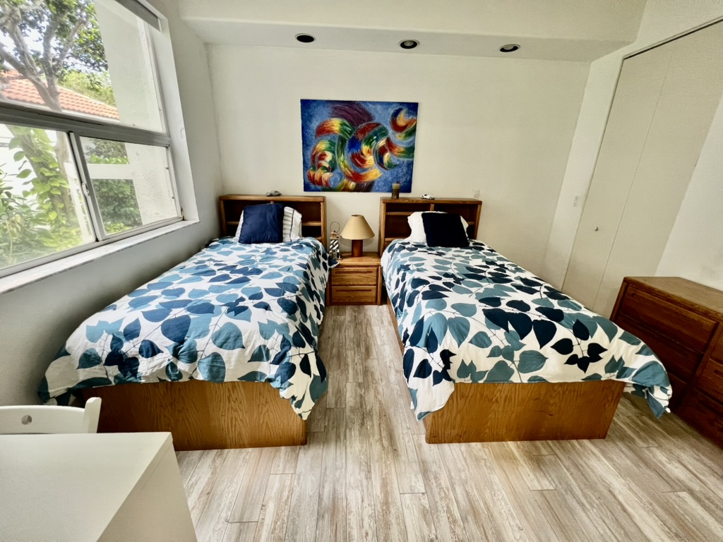 Guest bedroom with two twin beds and colorful art