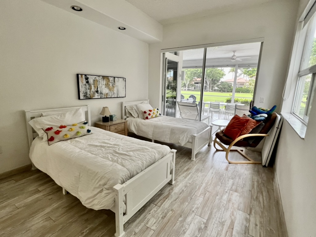 Guest bedroom with two twin beds and patio access