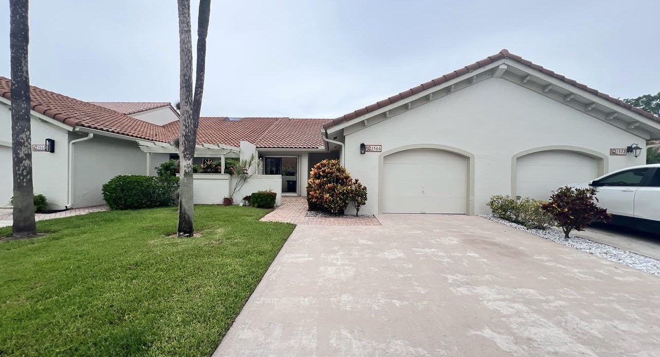 Villa front exterior with tile roof and driveway