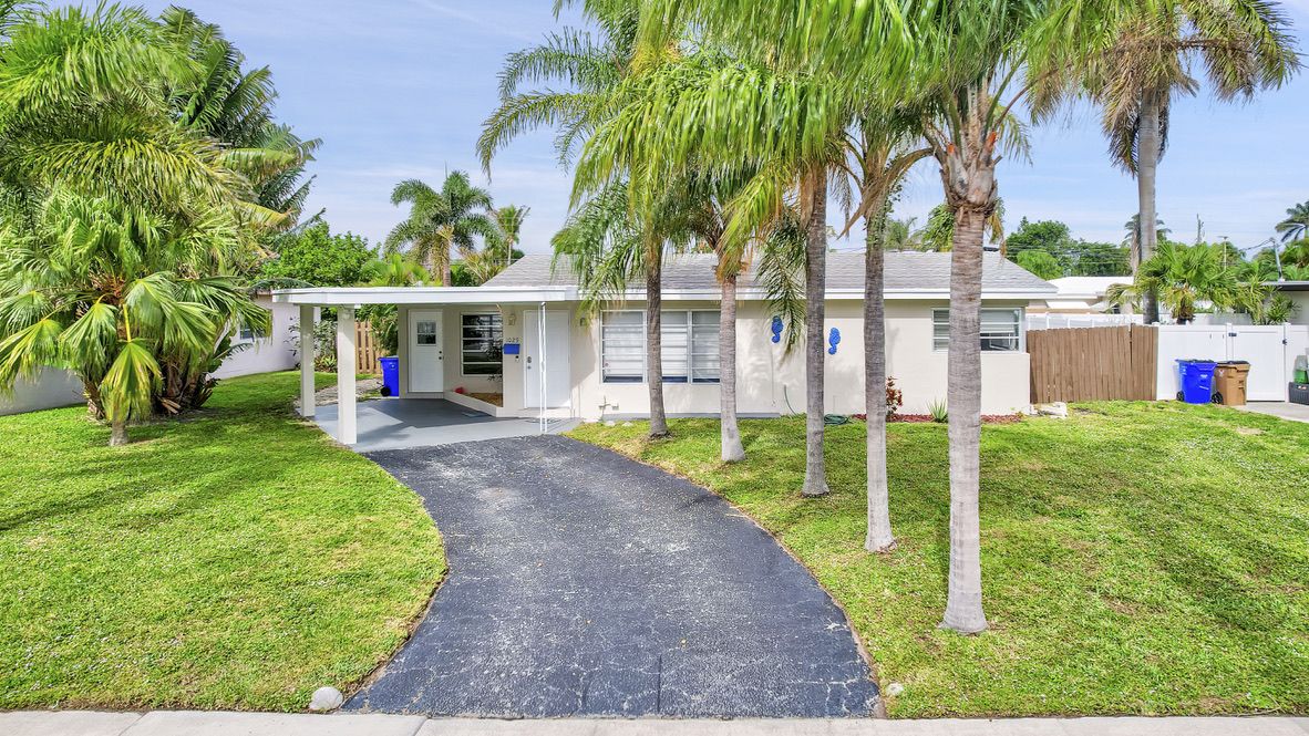 Front exterior with palm trees and driveway