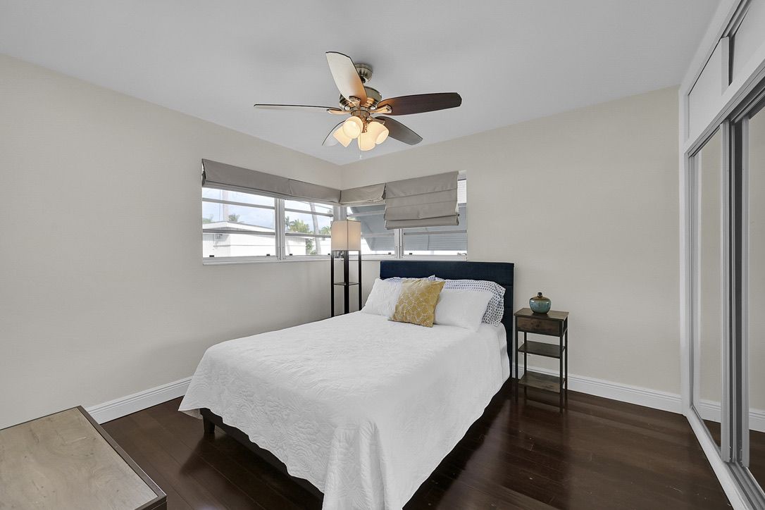Bedroom with white bedding and dark wood floors