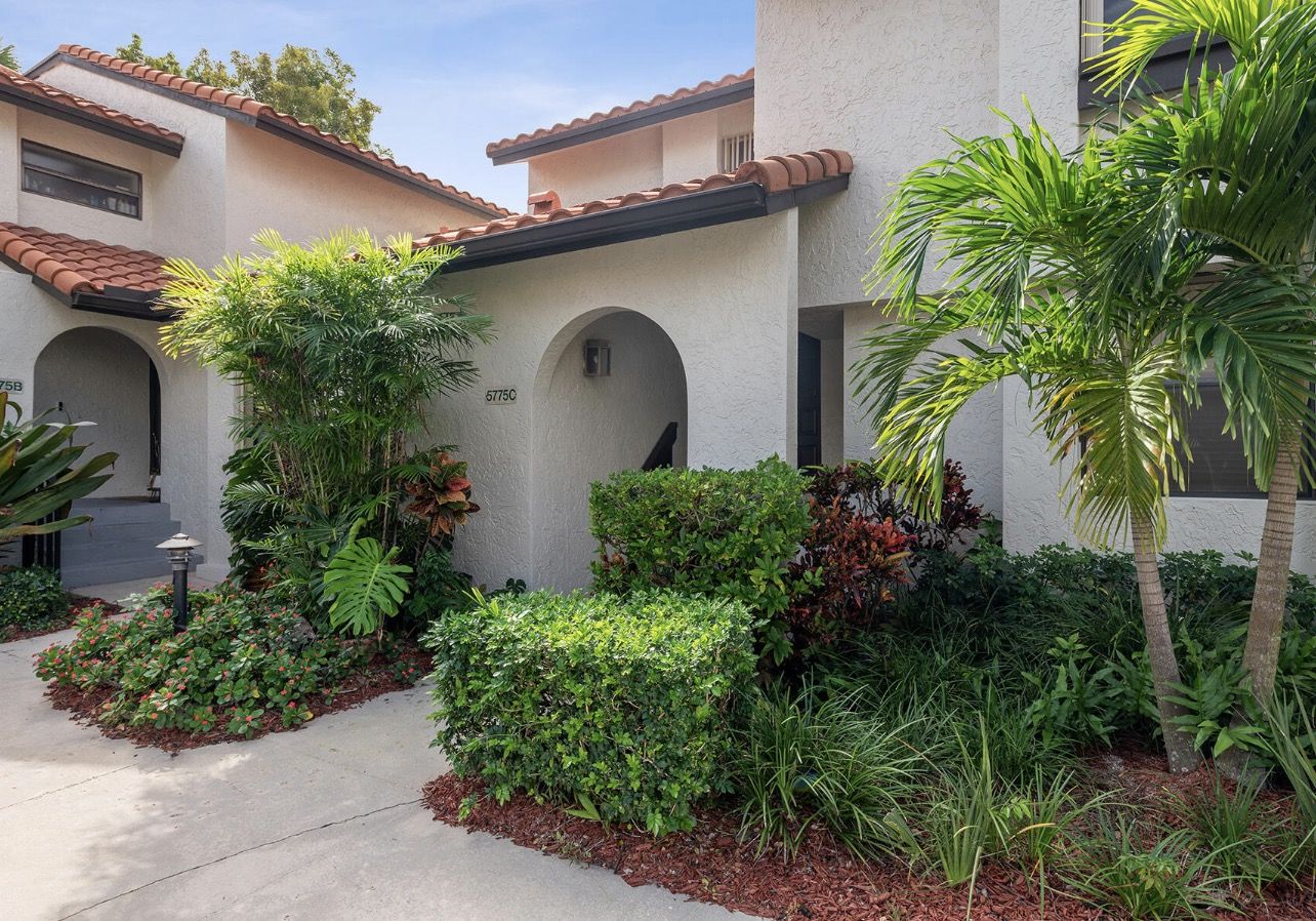 Townhouse entrance with palm trees and Spanish tile roof