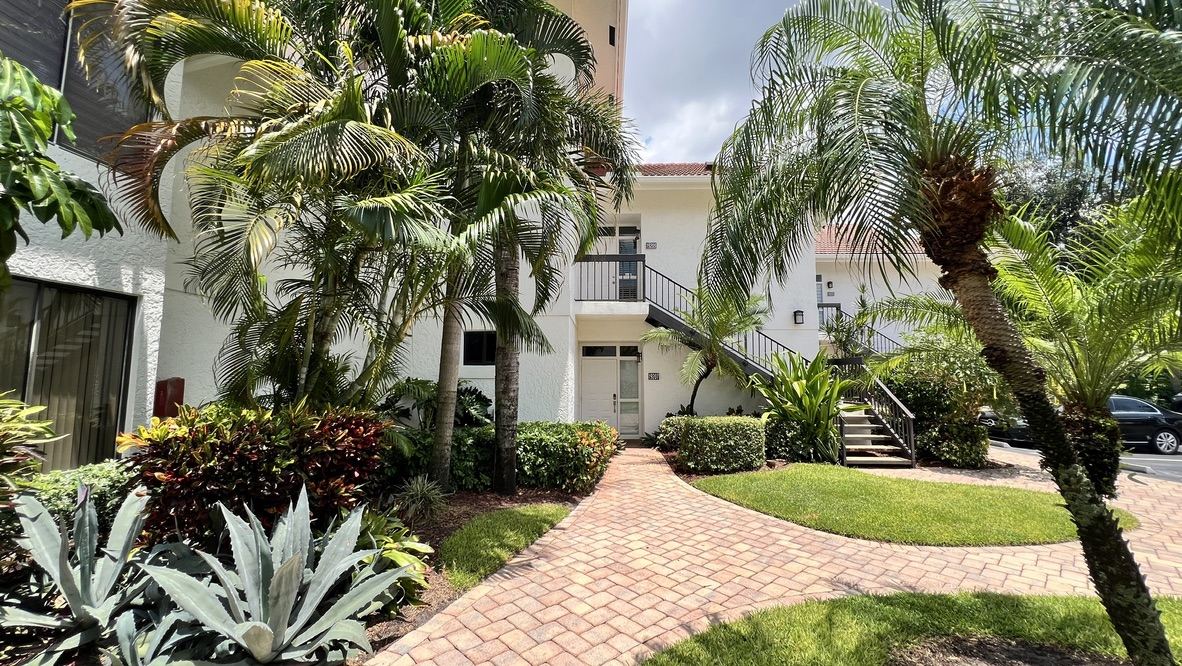 Building exterior with palm trees and walkway