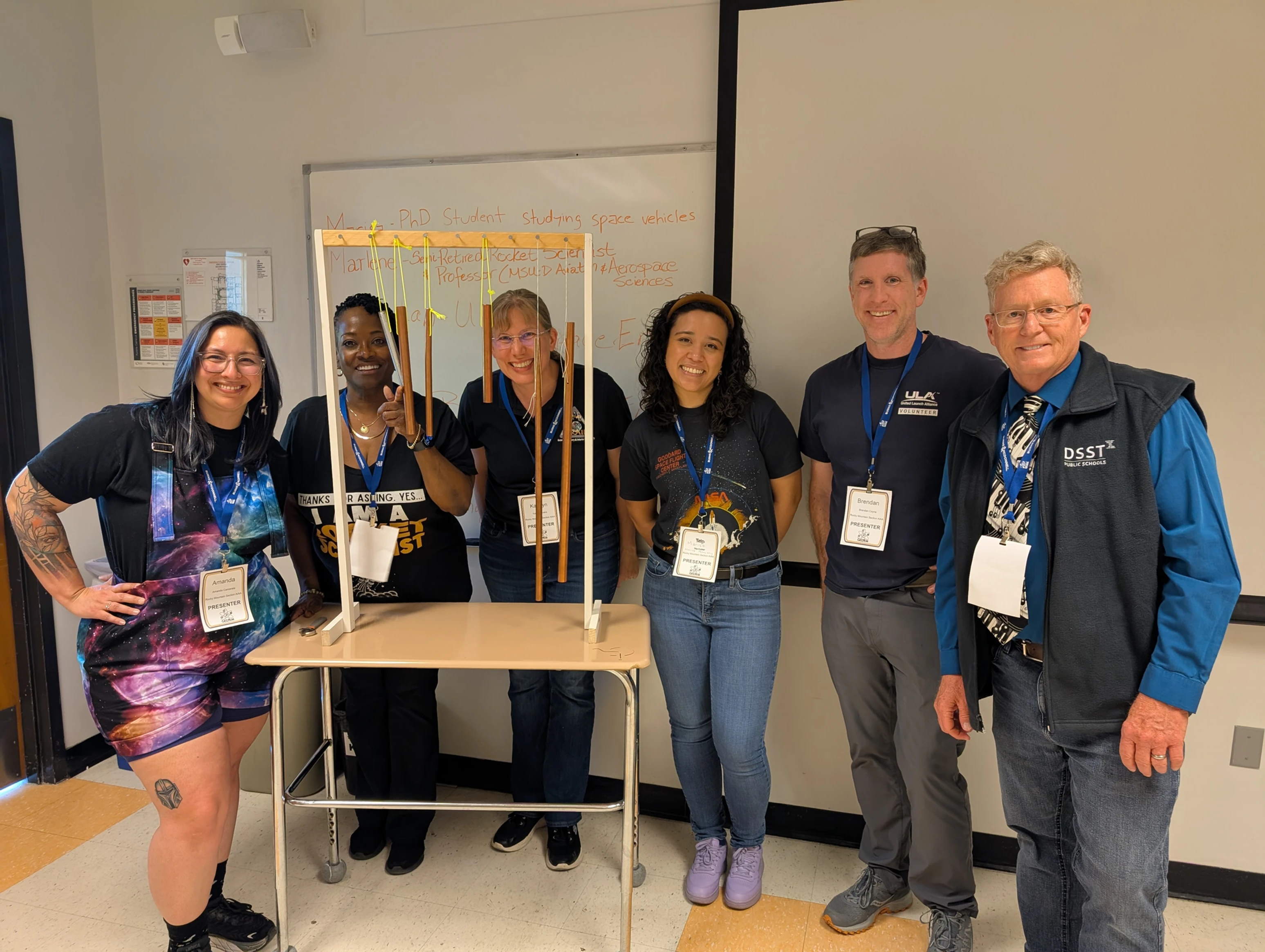 Group photo of the AIAA volunteers in front of a wind chime