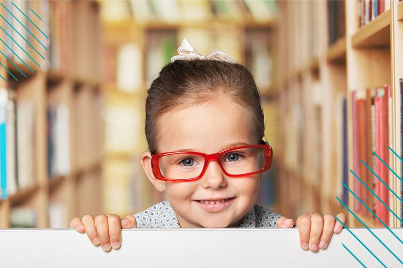 Retrato de una niña en una librería con gafas