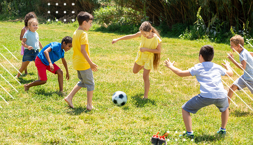 Niños jugando con un balón en el pasto