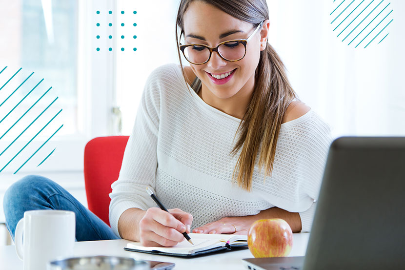 Mujer joven con lentes mientras toma notas