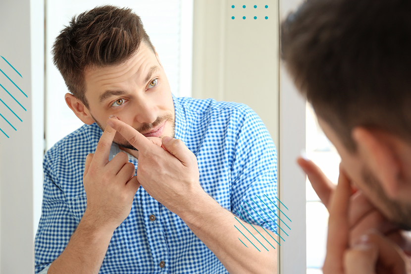 Retrato de hombre colocándose lentes de contacto en el espejo