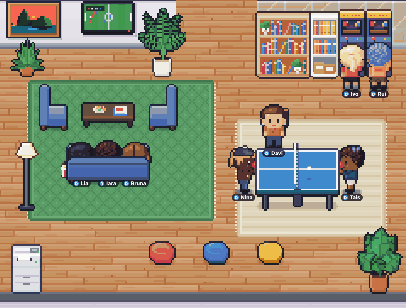 Habblaud lounge with three hangouts at once: three coworkers on the couch watching soccer on TV (the screen flashes GOL), a ping-pong match with fans and an arcade duel with trash talk in the bubbles