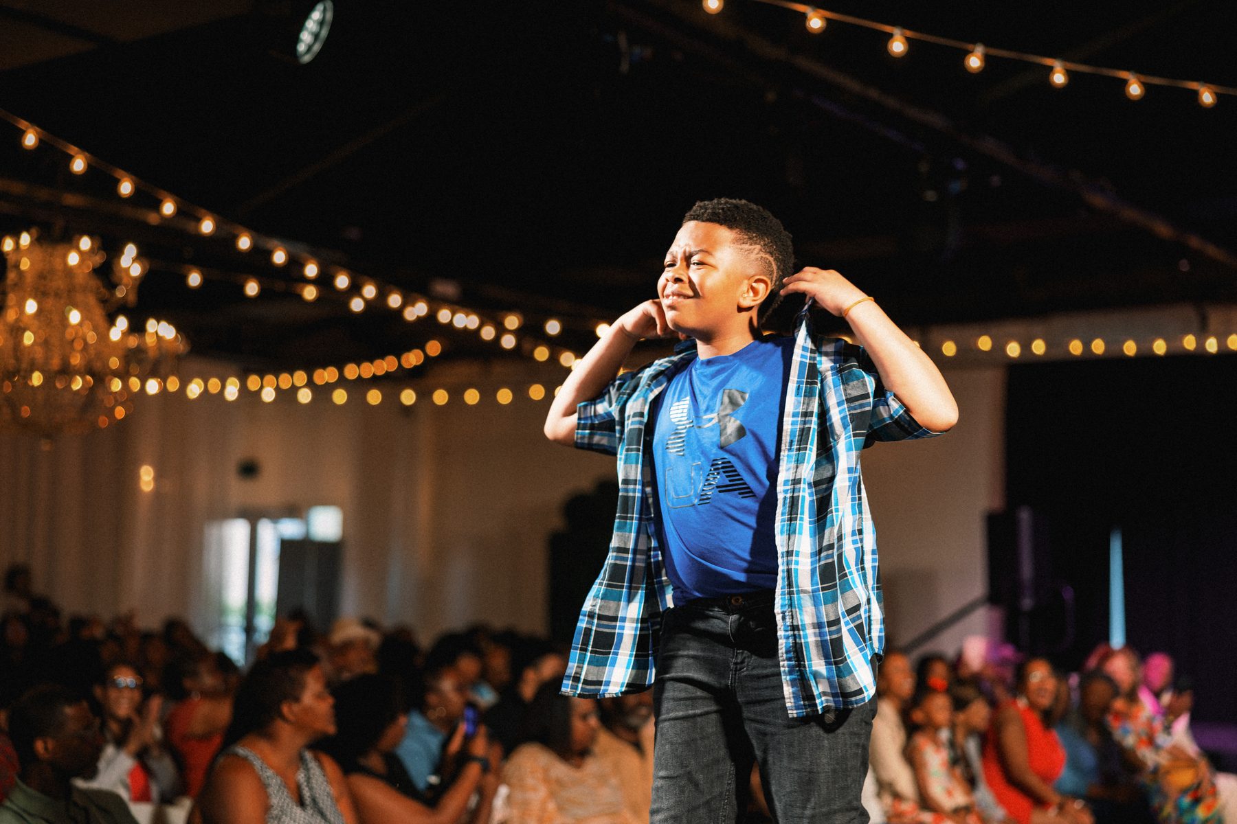 A young boy walks the stage with confidence at a TheGifted Arts showcase.