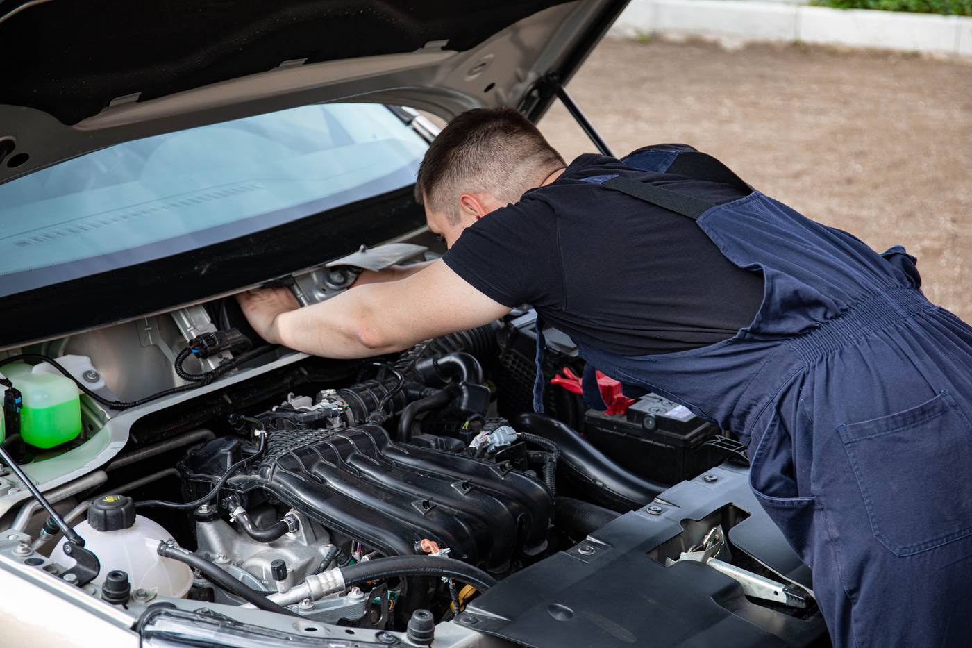 Mechanic inspecting a car engine with the hood open