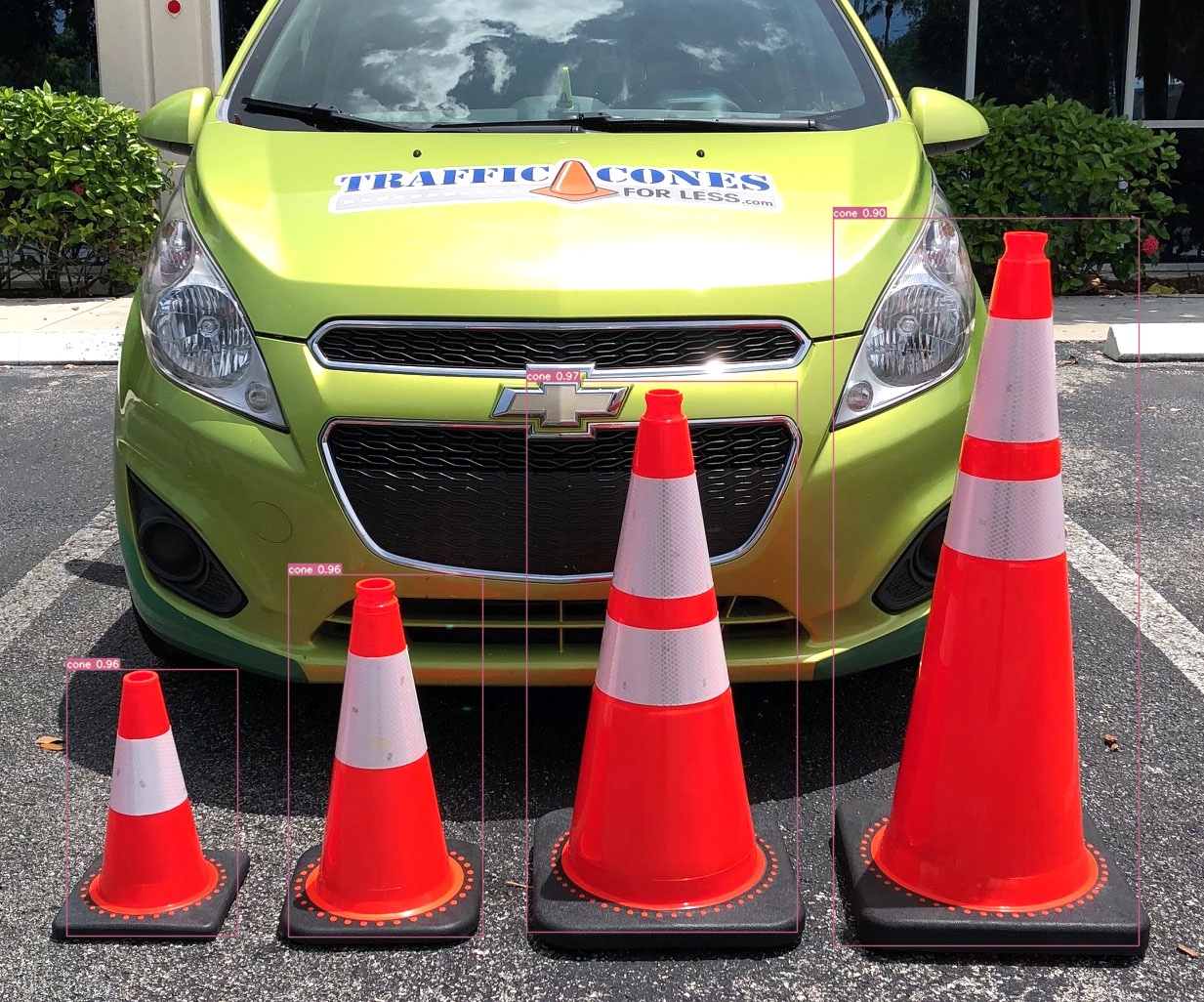 Image of four orange traffic cones of varying height in the foreground. All have a confidence score of 0.90 or above