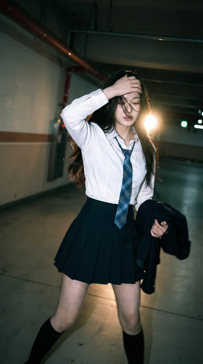 Candid portrait of a young woman in a dim parking garage,...