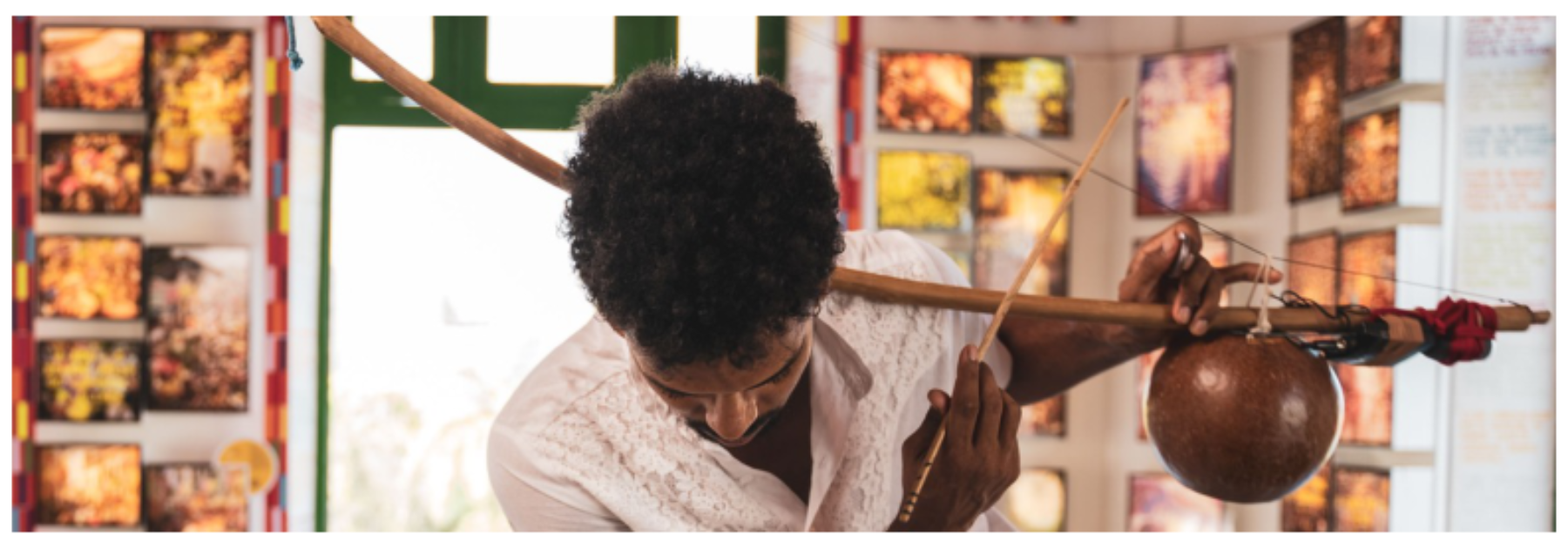 原论文 Figure 1:Orun Santana holding his Berimbau with a Giromin attached to it (photo by Junior Teles)