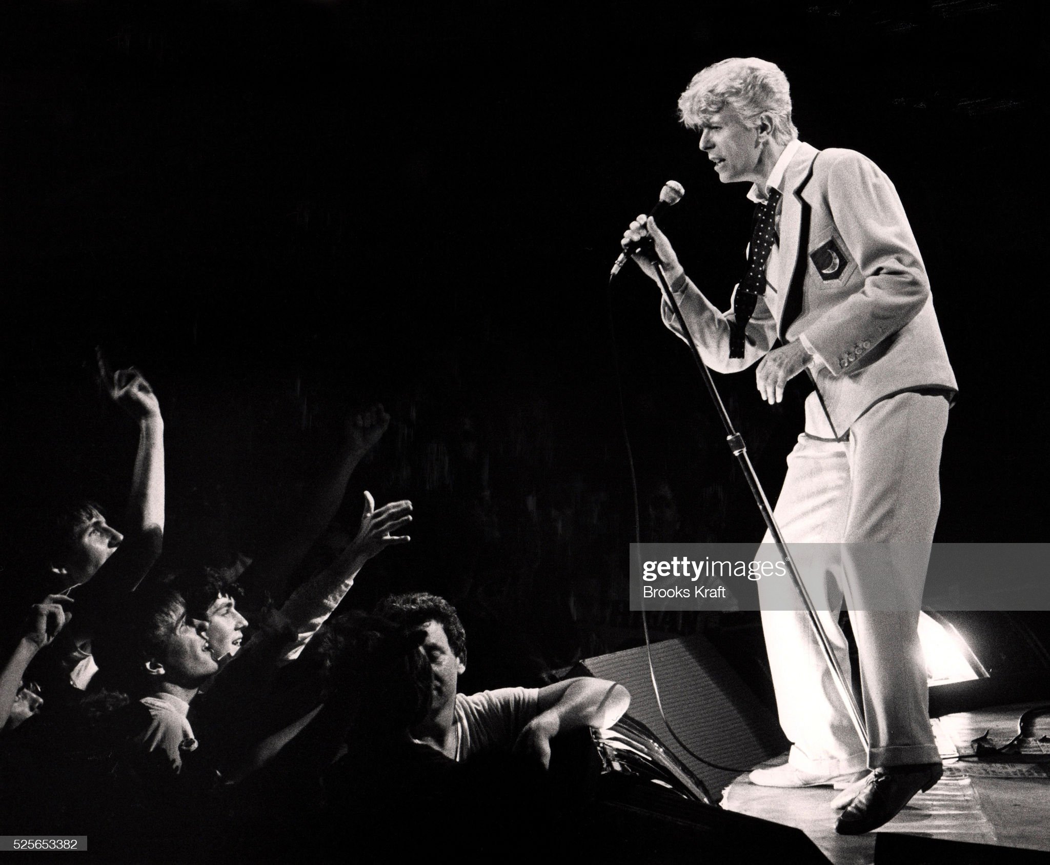 Fans reaching out to Bowie on stage.