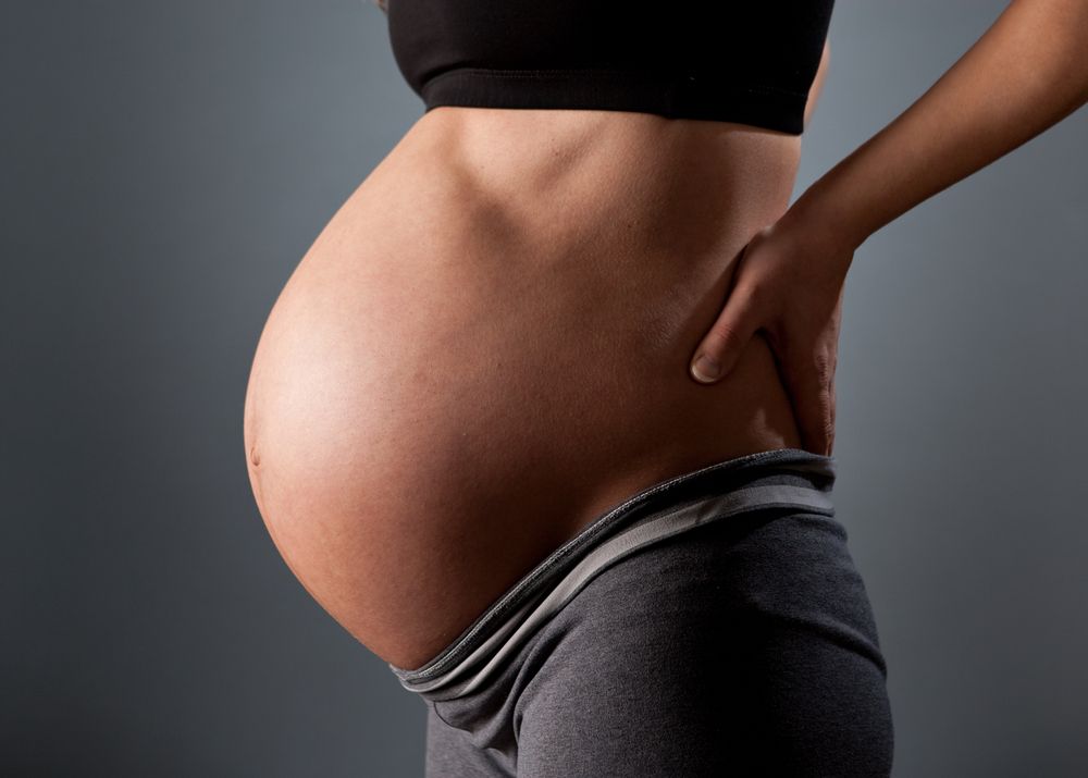 Trong những tháng cuối, trọng lượng thai dồn về phía trước gây đau hông cho bà bầu