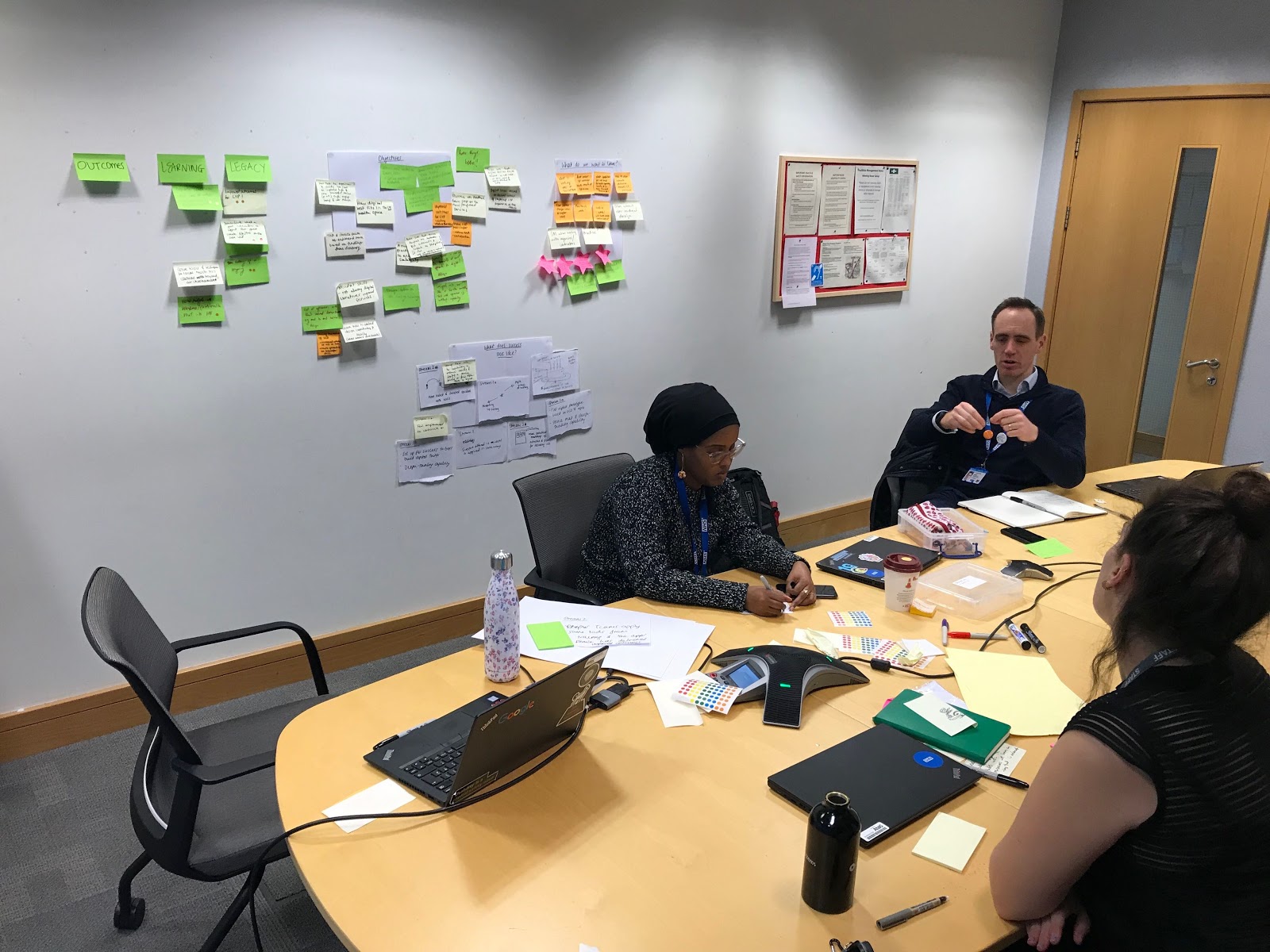 Team members around a table with post-it notes discussing objectives