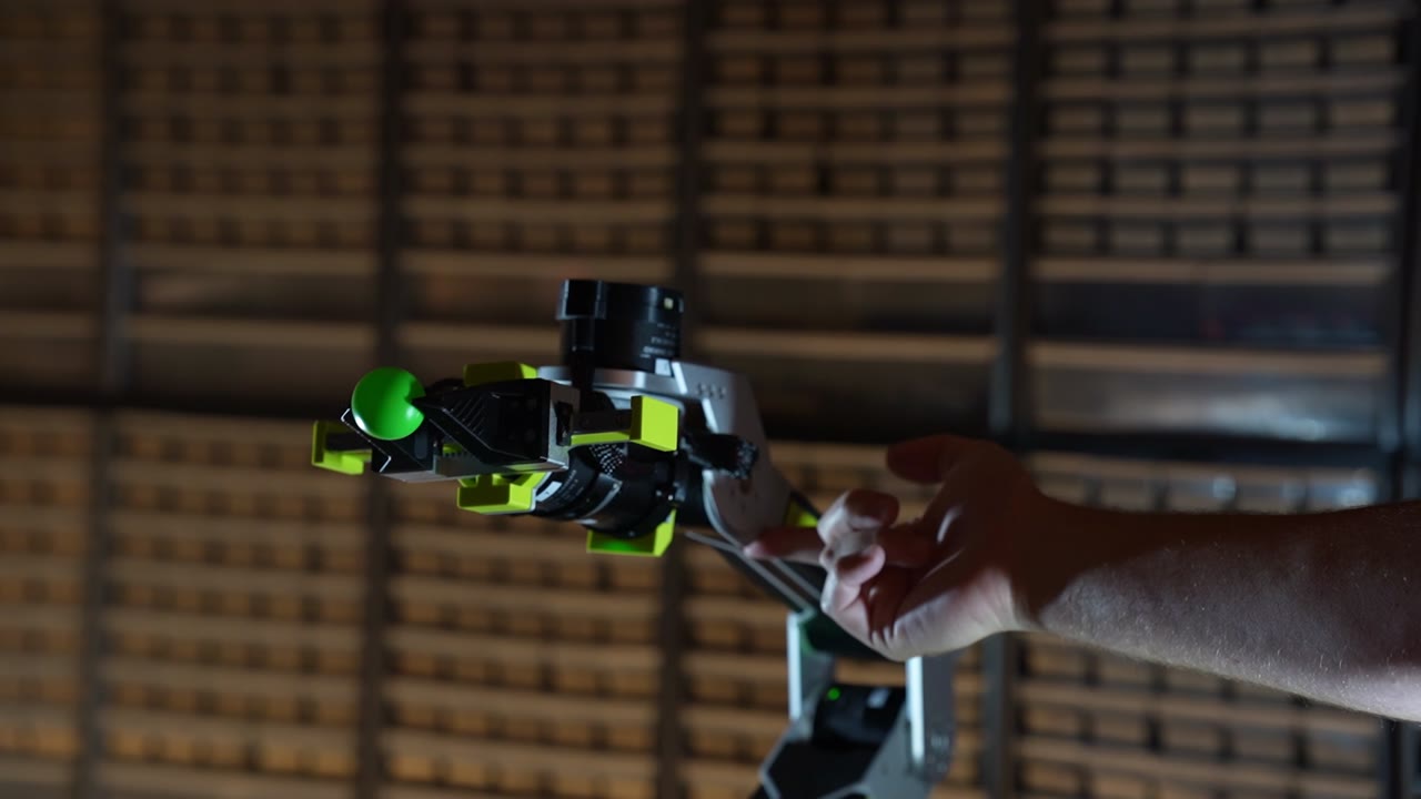 A person guides the reBot arm by hand while gravity compensation supports it.