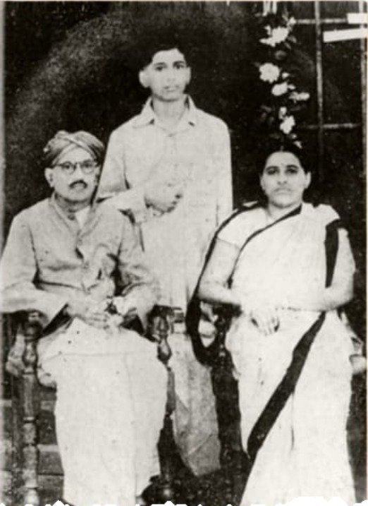 Young Narayana Bhat as a boy, standing between his father and mother
