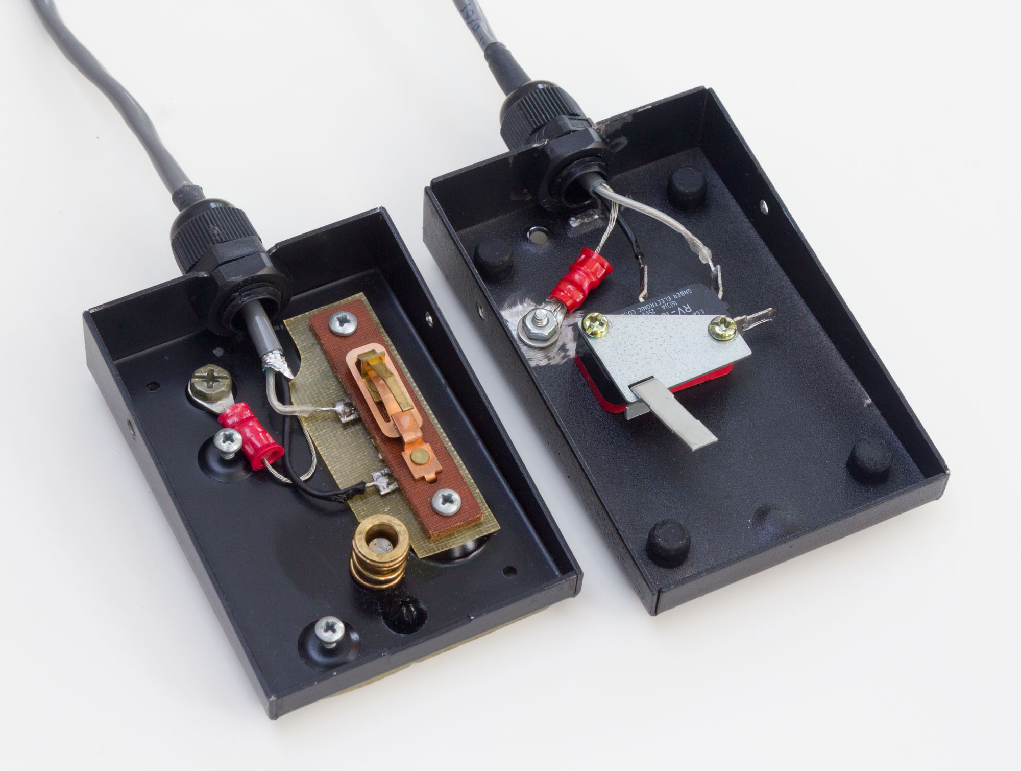 Photo of two footswitches with the tops removed to show the switches and wiring inside