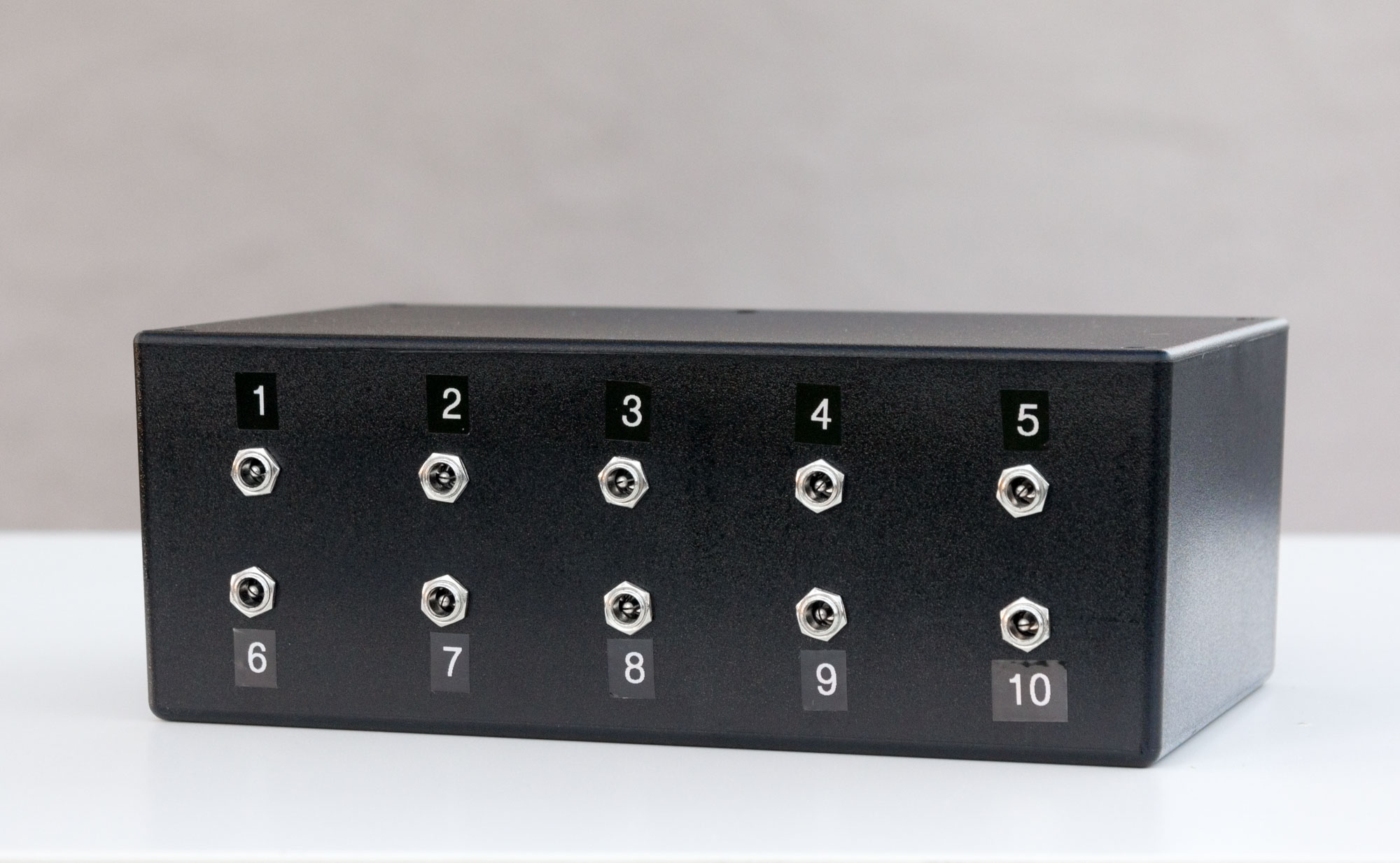 Photo of the outside of a black plastic box with ten connectors on the front