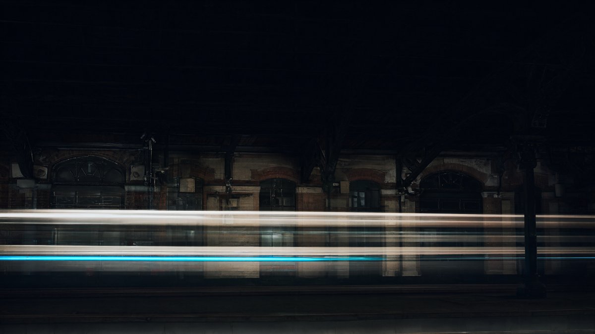 Long exposure of a train in a station hall at night