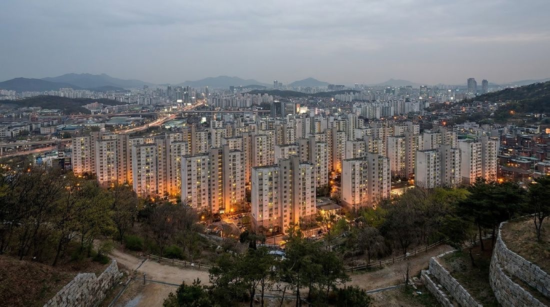 A Korean apartment complex seen from a hillside at dusk