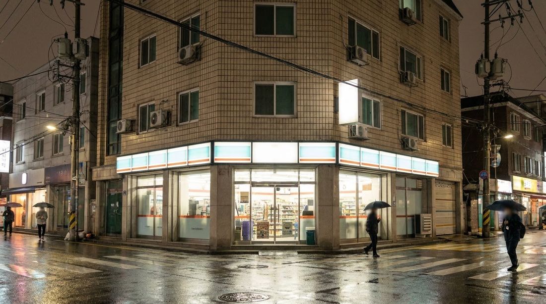 A convenience store on a residential corner in Seoul at night