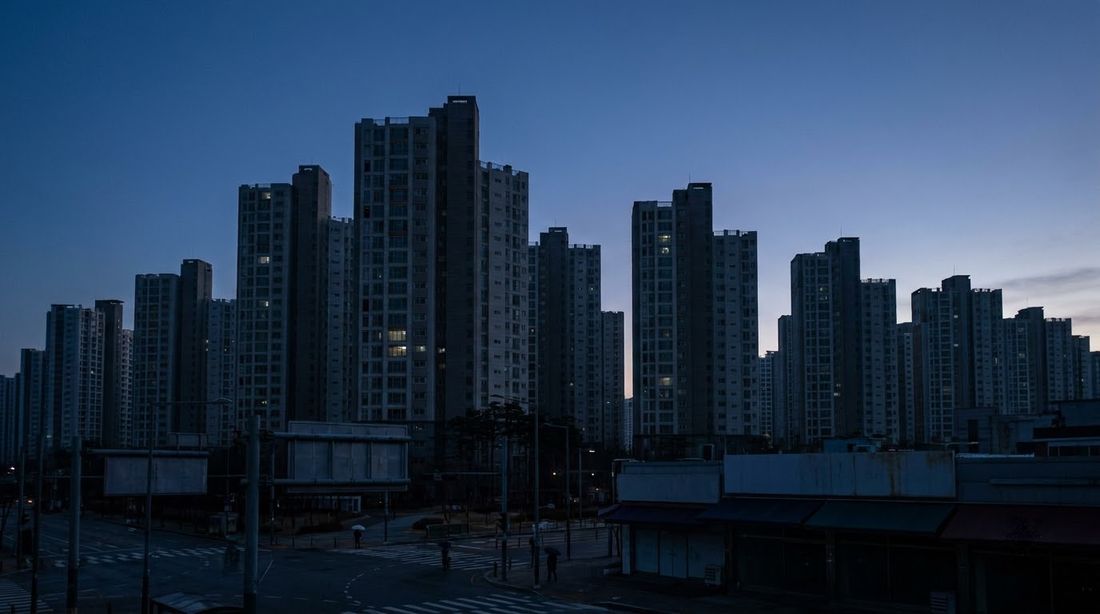 Korean apartment towers before sunrise with only a few windows lit