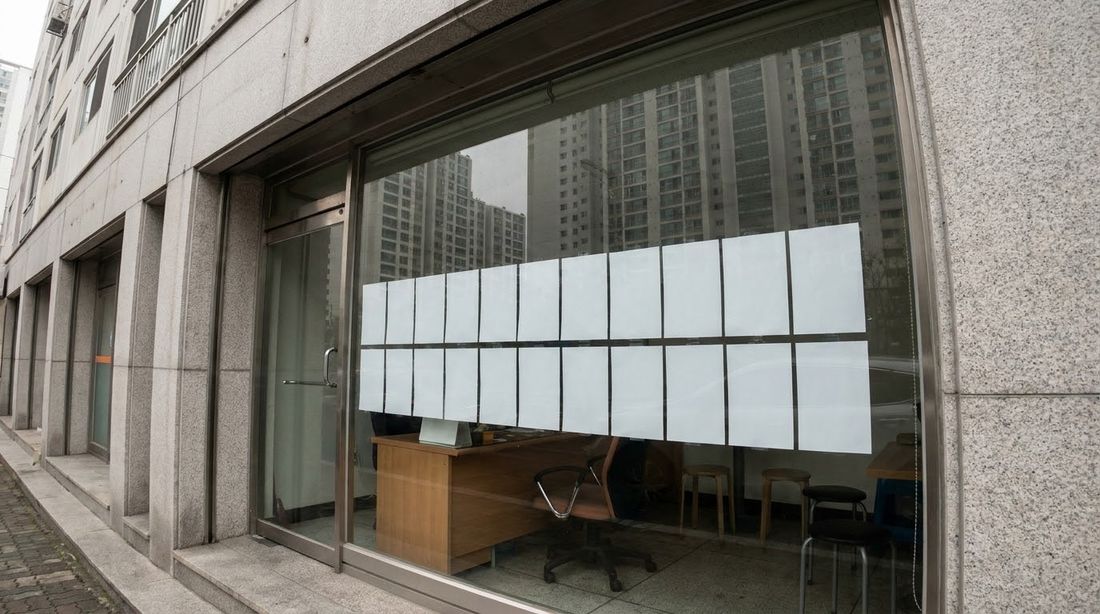 The window of a small Korean real-estate agency on the ground floor of an apartment complex