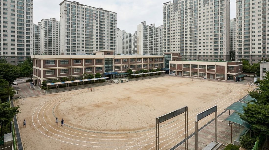A Korean elementary school and its yard surrounded by apartment towers