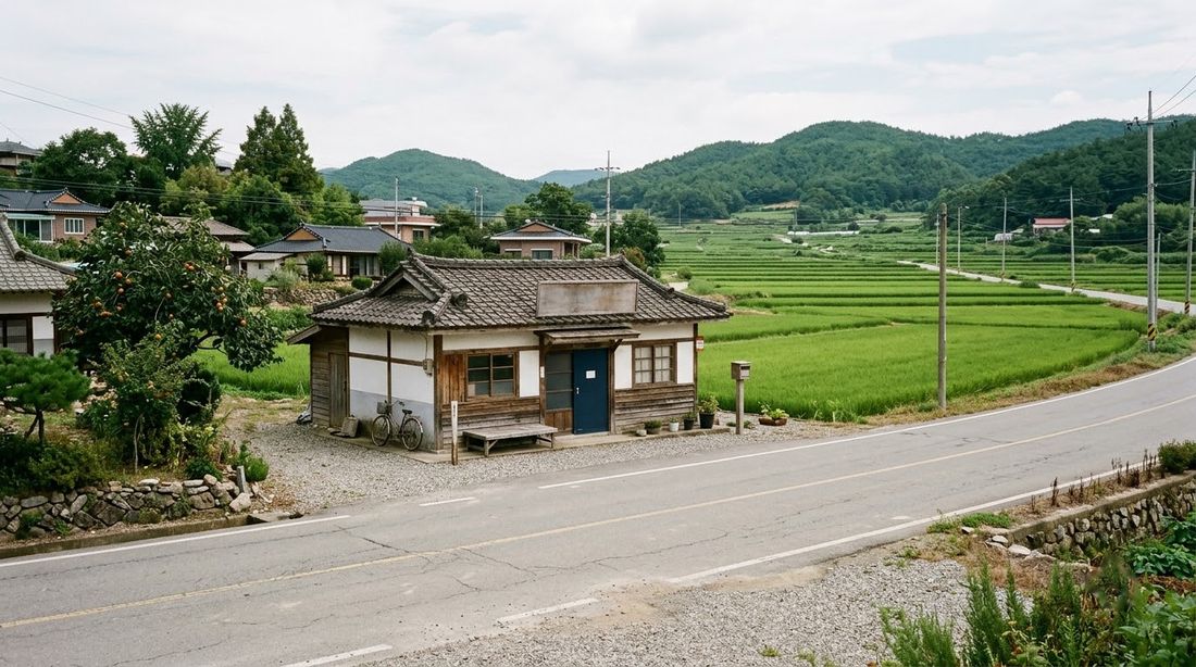 A small single-storey rural post office in a Korean village beside rice paddies and low hills