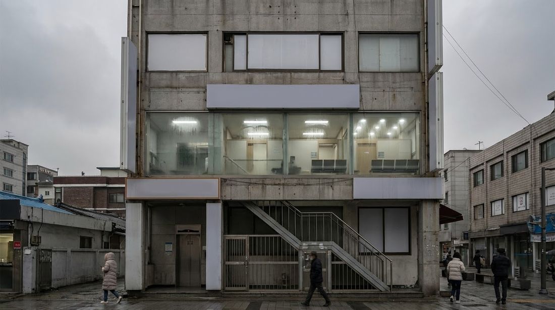 A Korean commercial building with small clinics stacked on its upper floors, within walking distance of most addresses