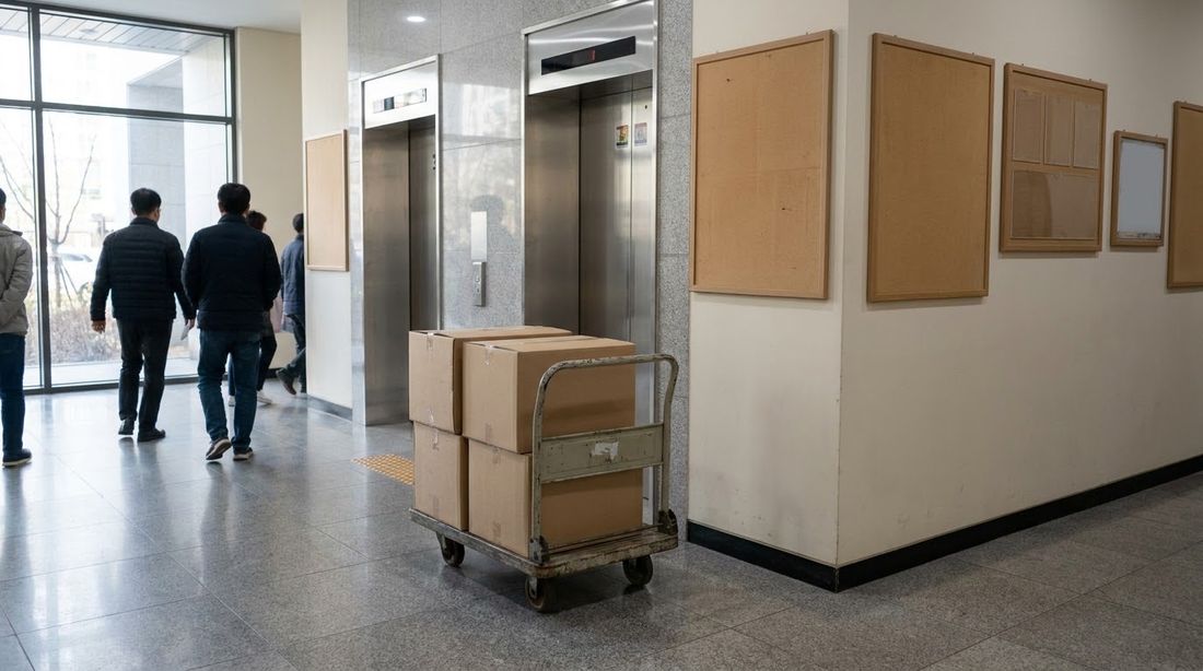 A dolly stacked with moving boxes waiting at an apartment elevator lobby in Seoul