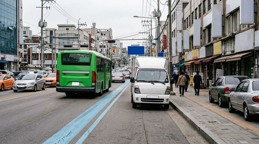A delivery truck blocking a curbside bus lane, forcing a city bus to merge back into ordinary traffic