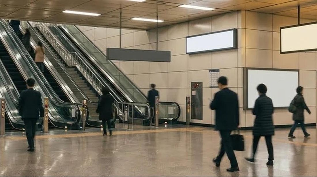 A wide underground station concourse with escalators