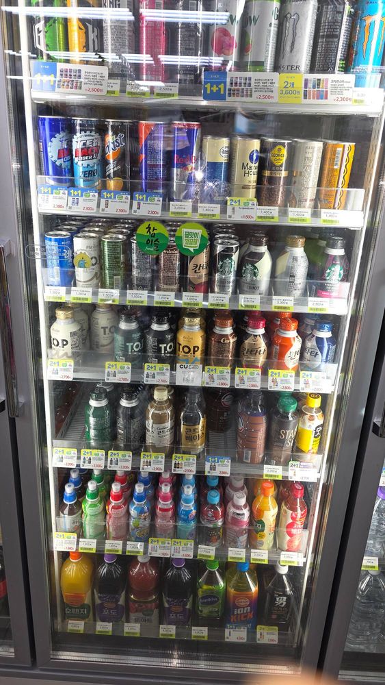 Drink cooler with 1+1 and 2+1 promotion tags on nearly every shelf
