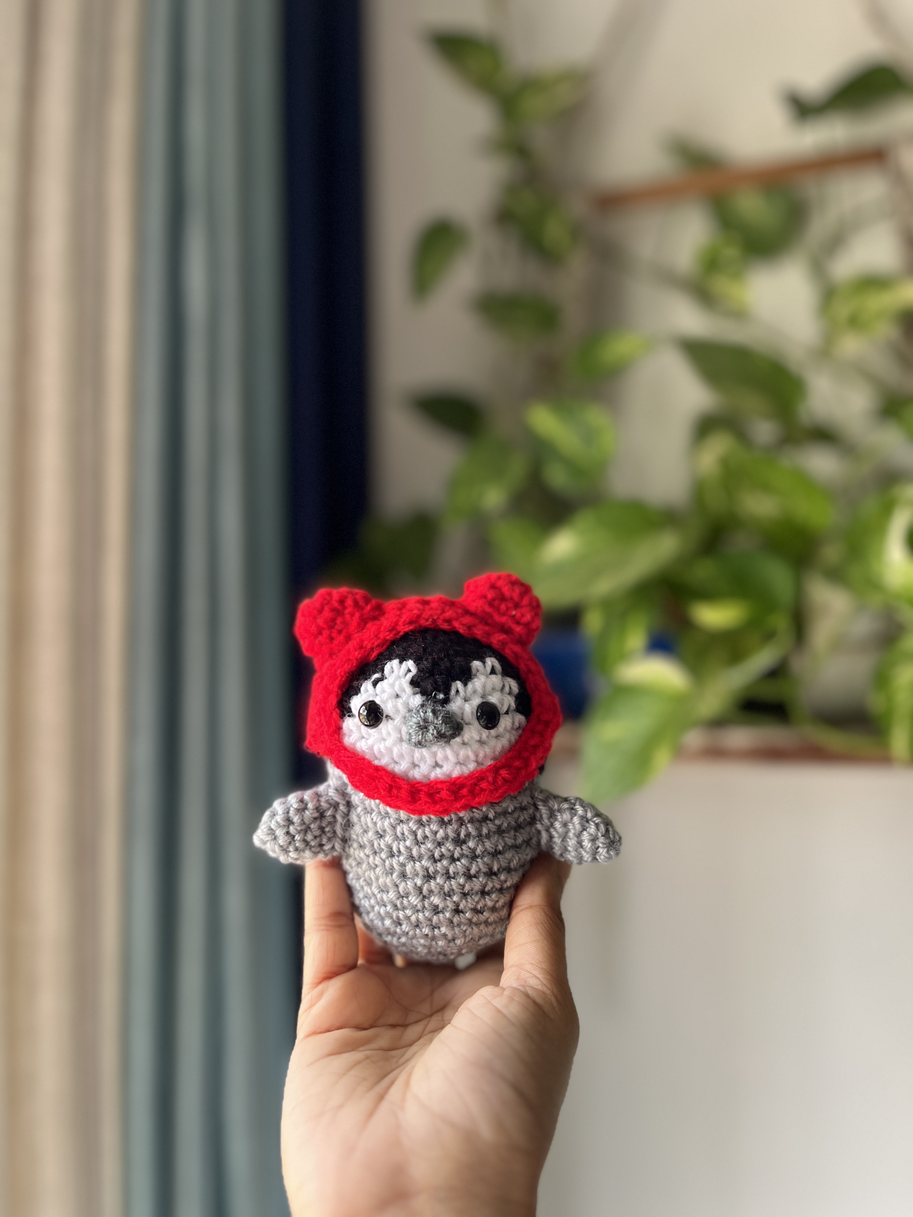 Tiny crochet winter hats on milk bottles with amigurumi characters in background