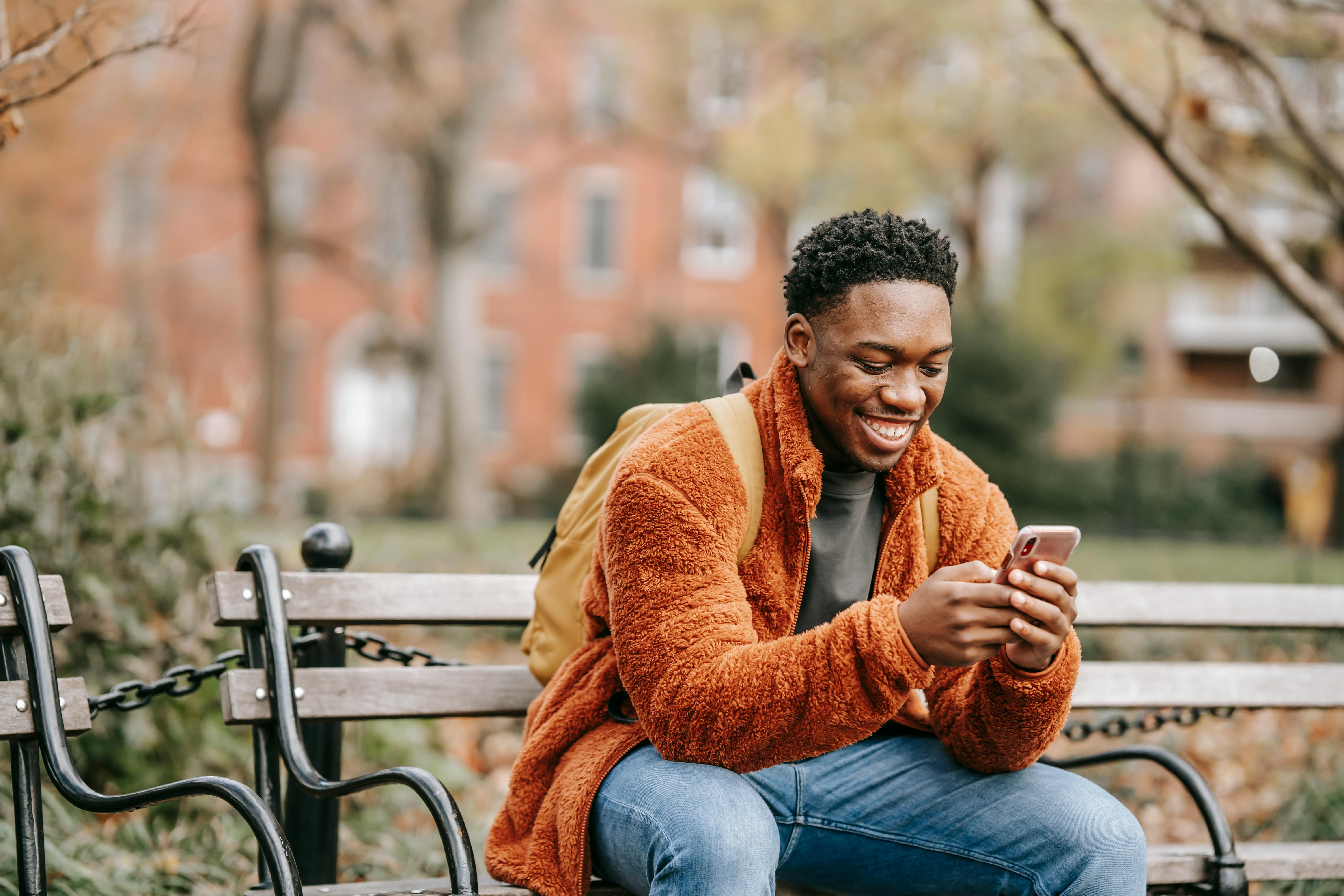 Man smiling reading a message on his phone