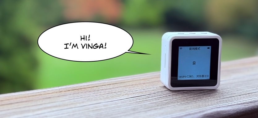 A Waveshare ESP32-S3-Touch-LCD-1.54 in a white case, standing on a weathered wooden rail with a blurred green garden behind it.