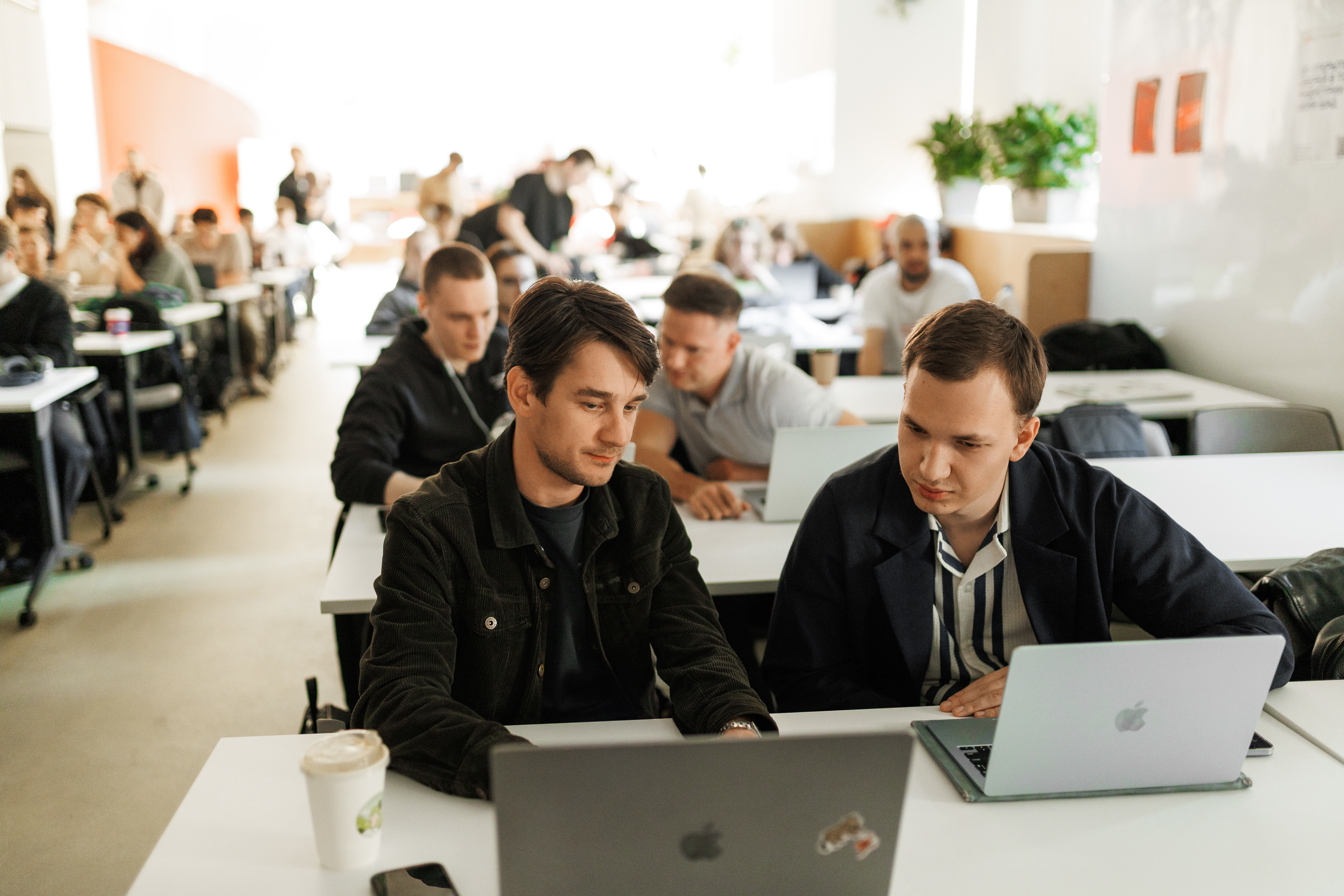 Участники AI Talent Hub работают вместе над задачей за ноутбуком