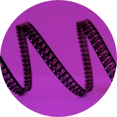 A circular logo with a reel of film in background with a purple tint and text 'Now Showing'
