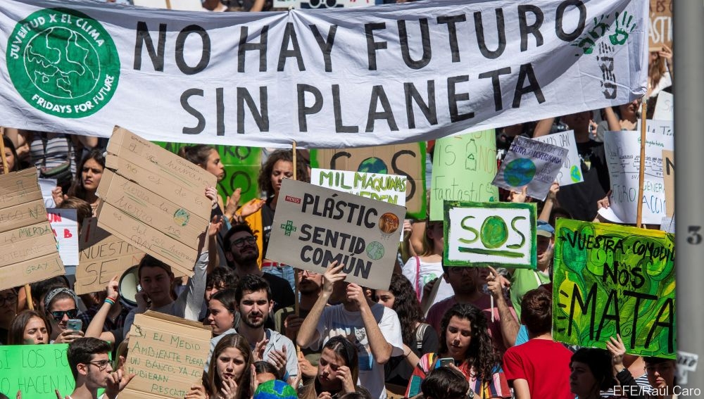 Personas marchando con una lona que dice 'no hay futuro sin planeta'