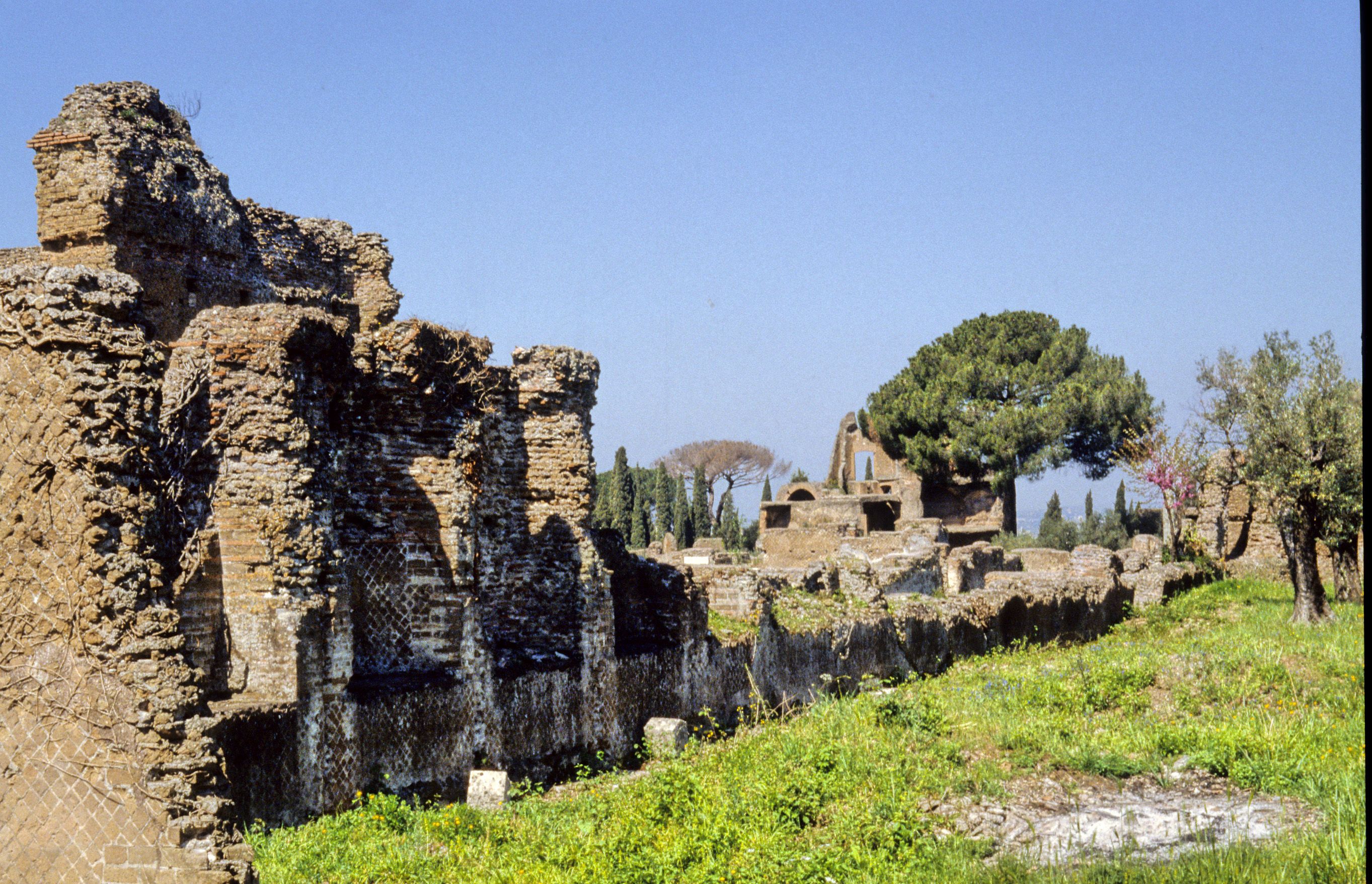Second photograph of the high wall, decorated by a series of alternating semicircular and square niches, which once enclosed the peristyle-garden on the eastern side of the Republican villa at Hadrian's Villa