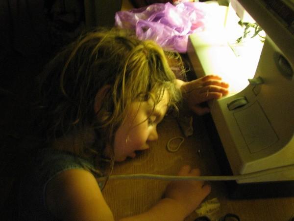 Enfant endormi devant une machine à coudre