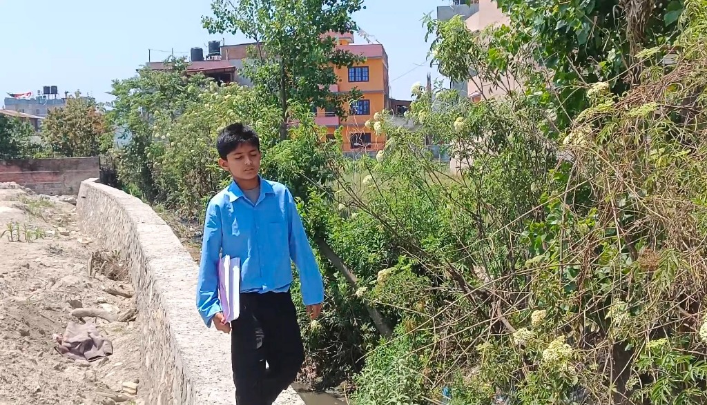 Milan carrying his study materials in Kavre, Nepal