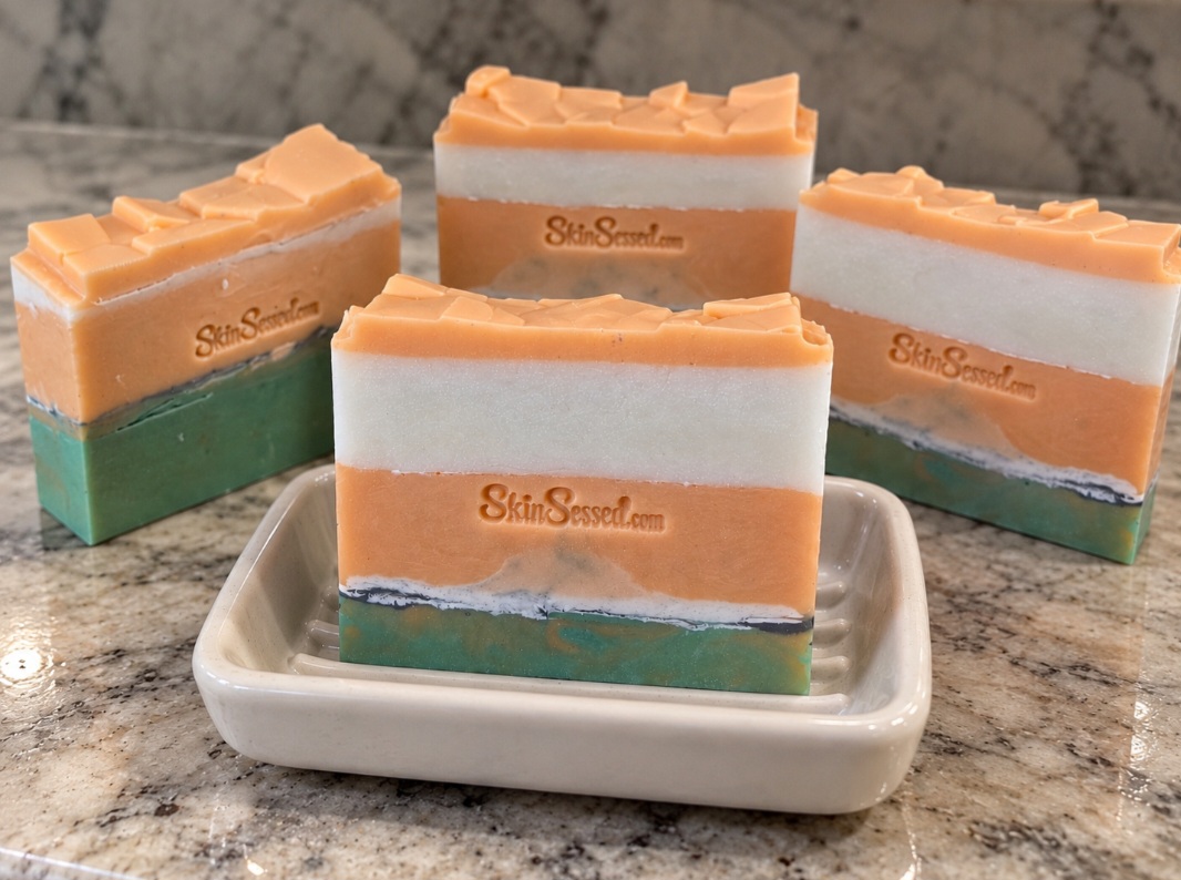 SkinSessed handmade goat milk soap bars with peach-orange, white and green layers
