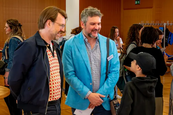 Stefan Hanitzsch im Gespräch mit Stadtschulrat Florian Kraus (Grüne) und dem Spieler in der Rolle des Bundeskanzlers Murat Jabr beim World Peace Game