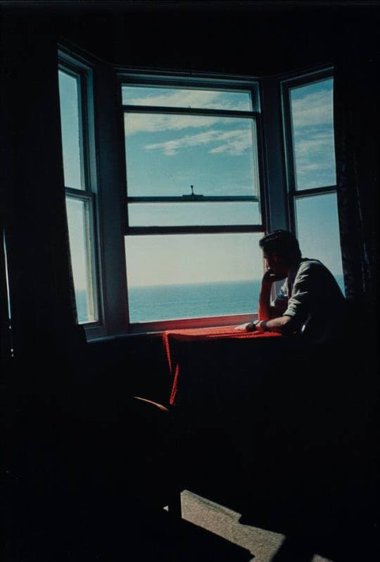 A man sitting at a table in a room overlooking the ocean, San Francisco, California by Joel Sternfeld (1979)