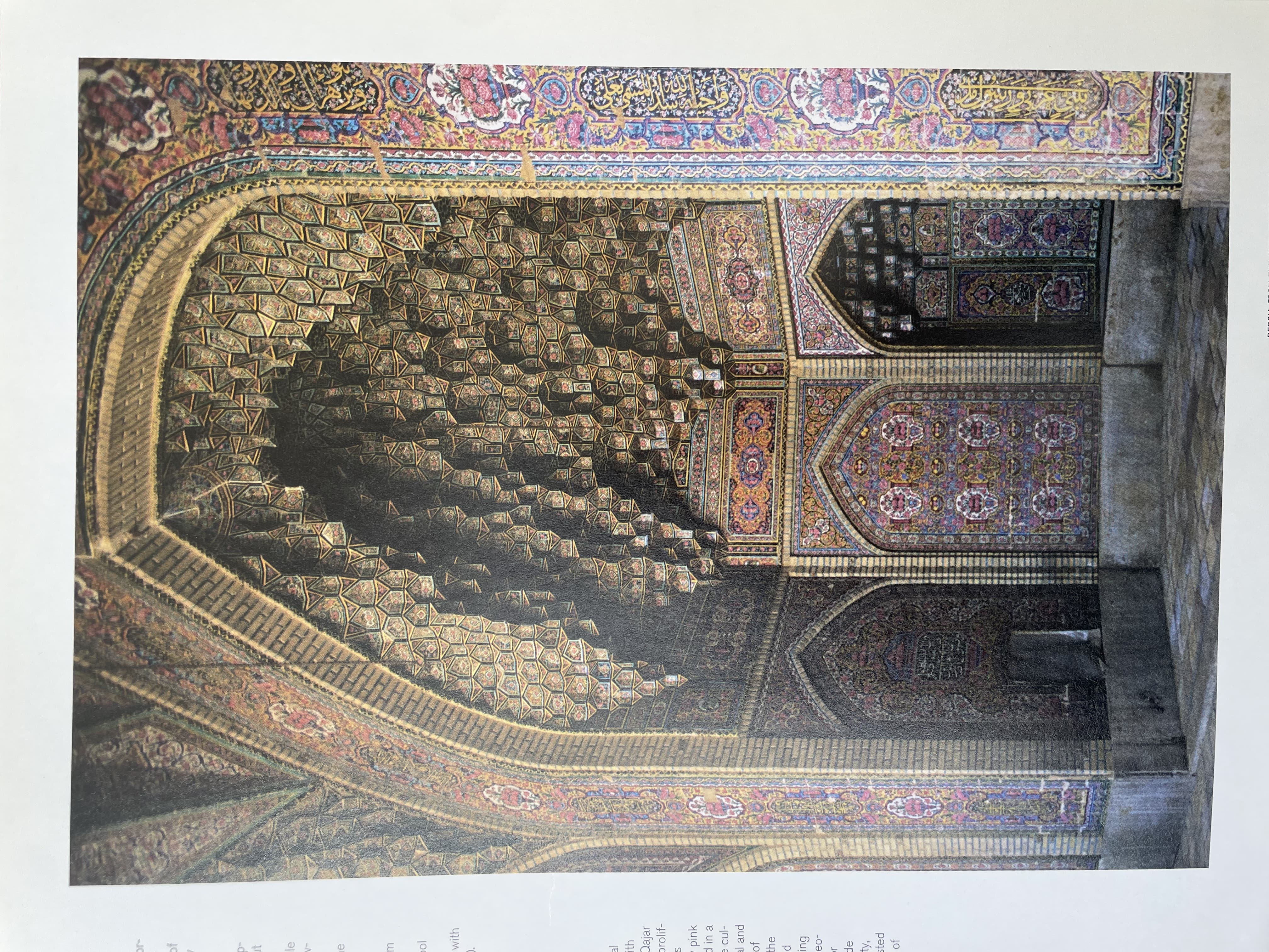 Photograph of an Interior Archway with Intricate Muqarnas and Colorful Floral Tilework
